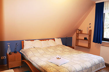 Das Bett im Schlafzimmer der Dachgeschoss-Wohnung