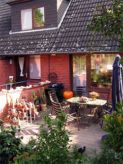 Blick aus dem Garten heraus auf die Terrasse